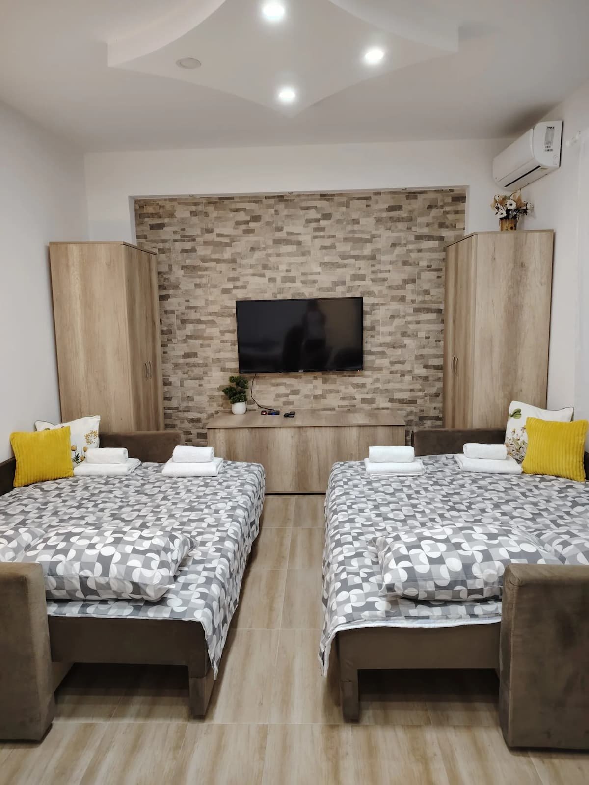 Prostor za spavanje u Studiju 1 sa dva ležaja i kamenim zidom